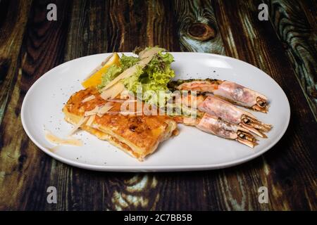 Langoustines avec jeunes pommes de terre. Un plat avec de grandes crevettes royales, des homards avec des légumes. Banque D'Images