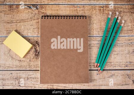 Autocollants, blocs-notes et crayons verts pour réfrigérateur sur fond de bois marron. Papeterie, notes et organiseur pour les affaires, la motivation et la formation. Banque D'Images