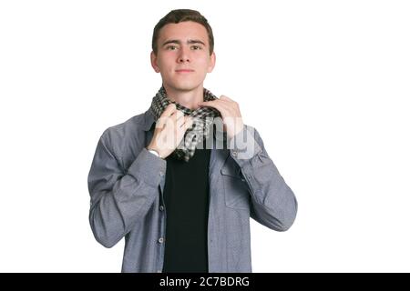 Un jeune homme dans une chemise de Manatee, un t-shirt et un pantalon noirs, isolés sur des robes blanches. Une écharpe à carreaux est nouée Banque D'Images