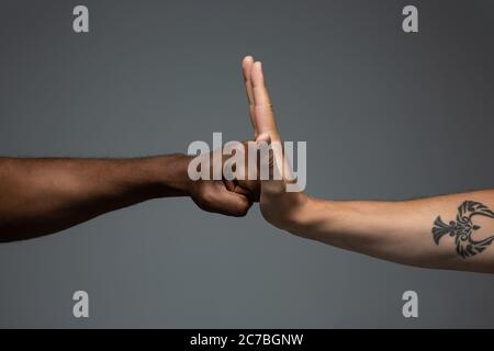 Arrêter le racisme. Tolérance raciale. Respecter l'unité sociale. Des mains africaines et caucasiennes sur fond gris de studio. Droits de l'homme, amitié, concept d'unité intenationale. Unité interraciale. Banque D'Images