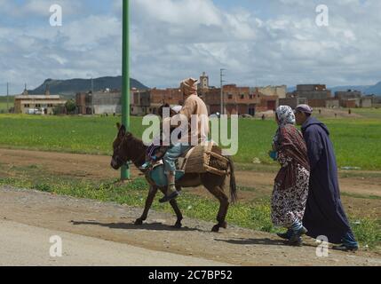 Famille berbère à cheval sur des ânes à Beni Mellal près de Marrakesch dans les montagnes de l'Atlas, au Maroc Banque D'Images