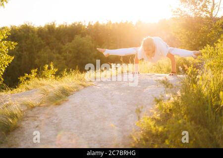 Jeune femme exécutant la posture de Firefly. Fille faisant des exercices de yoga avancés, se penchent sur les mains Banque D'Images