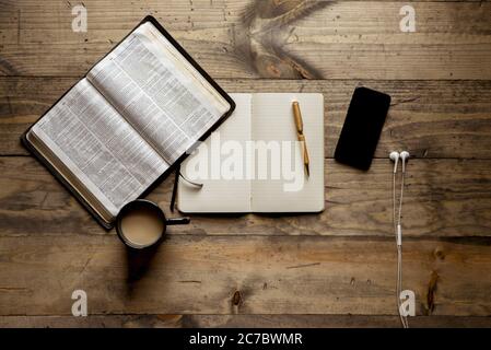 Photo d'un ordinateur portable avec un stylo plume à proximité un livre ouvert et un smartphone sur une table en bois Banque D'Images