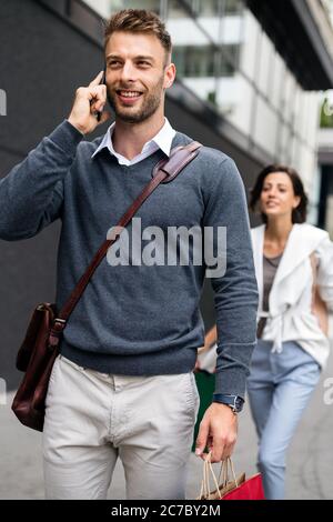 Portrait d'un jeune homme beau avec des sacs de shopping Banque D'Images