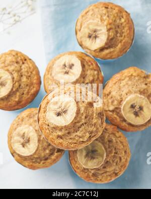 Muffin à la banane, vue de dessus, gros plan, vertical. Petit-déjeuner le matin sur une serviette bleue Banque D'Images