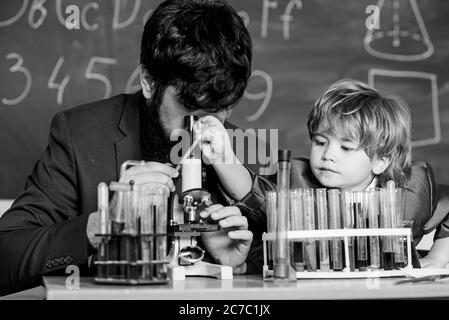 L'activité d'enseignement de l'étude par l'expérience. J'aime étudier dans l'école. Enseignant et garçon en laboratoire de chimie. Étudier la chimie et la biologie. L'étude est intéressante. L'exemple personnel et d'inspiration. Banque D'Images