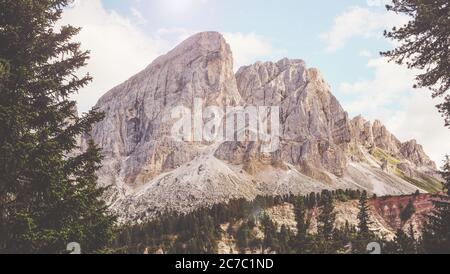 Une grande photo de hautes montagnes rocheuses entourées d'arbres verts sous le ciel nuageux à San Martino, Badia Banque D'Images