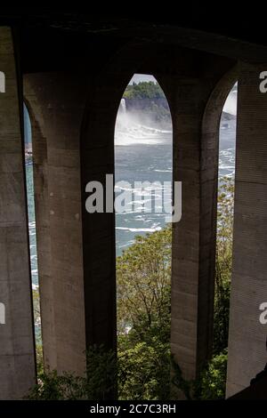 Plan vertical où des arcs de pierre couvrent une vue du rivière où chute une cascade Banque D'Images