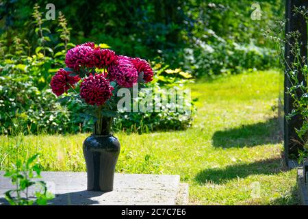 Tombe aux fleurs rouges fraîches dans le cimetière juif de Weissensee Berlin Banque D'Images