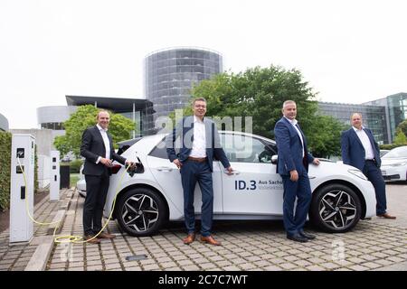Dresde, Allemagne. 16 juillet 2020. Wolfram Günther (Bündnis90/Die Grünen, l-r), Ministre de l'Environnement de Saxe, Reinhard de Vries, Directeur général de Volkswagen Saxe, Lars Dittert, Directeur du site de l'usine transparente Dresde, Et Dirk Hilbert (FDP), seigneur maire de Dresde, se tiennent devant l'usine transparente dans un VW ID.3 à l'occasion de l'agrandissement d'un parc de chargement pour voitures électriques. Le parc de chargement comprend un total de 36 points de chargement publics. Credit: Sebastian Kahnert/dpa-Zentralbild/dpa/Alay Live News Banque D'Images