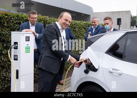 Dresde, Allemagne. 16 juillet 2020. Wolfram Günther (Bündnis90/Die Grünen, M), ministre de l'Environnement de Saxe, se tient dans une station de charge devant l'usine transparente en face de Reinhard de Vries (l), directeur général de Volkswagen Saxe, Et Lars Dittert (2e à partir de la droite), gérant de site transparent Factory Dresden, à l'occasion de l'agrandissement d'une station de charge pour voitures électriques. Au total, le parc de chargement comprend 36 points de recharge publics. Credit: Sebastian Kahnert/dpa-Zentralbild/dpa/Alay Live News Banque D'Images