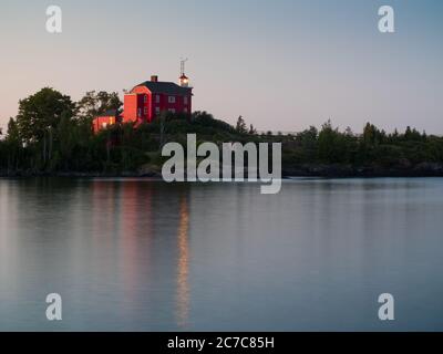 Paysage photo d'un lac calme avec une maison rouge sur la rive Banque D'Images