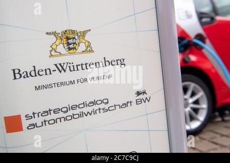 15 juillet 2020, Bade-Wurtemberg, Mühlhausen im Täle: Une station de charge avec l'inscription 'Ministère des Transports de Bade-Wurtemberg' et 'dialogue stratégique avec l'industrie automobile BW' se dresse devant un e-car. Photo: Sebastian Gollnow/dpa Banque D'Images