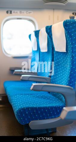 Une rangée de sièges vides sur un train de banlieue japonais allant d'Osaka à Tokyo en raison des restrictions de voyage Covid-19 moins de passagers, sièges bleus, train à grande vitesse. Banque D'Images