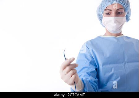 Femme médecin ou infirmière portant un costume ou une robe bleu stérile portant un cathéter d'ablation pour une procédure cardiaque. Concentrez-vous sur le cathéter Banque D'Images