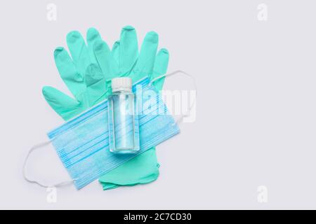 disposition plate des articles d'hygiène - gants en latex, masque et désinfectant pour les mains sur fond gris clair Banque D'Images