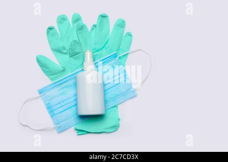 disposition plate des articles d'hygiène - gants en latex, masque et désinfectant pour les mains sur fond gris clair Banque D'Images