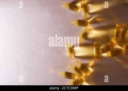Les vitamines Omega 3 de Golden Capsules se trouvent sur fond blanc Banque D'Images
