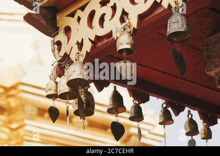 Gros plan de cloches en laiton accrochées à un temple asiatique toit Banque D'Images