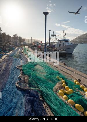 Pile de différents filets de pêche utilisés pour la pêche en mer et le chalutage sur les quais. Le bateau de pêche attend le quart suivant Banque D'Images