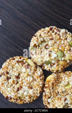 Biscuits faits maison aux céréales et raisins secs sur une ancienne table en bois. Biscuits aux céréales fraîchement cuits aux flocons de maïs sur fond de bois Banque D'Images