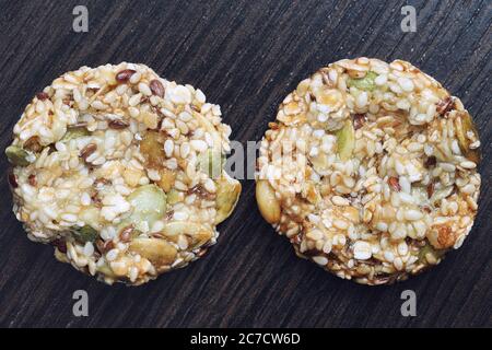 Biscuits faits maison aux céréales et raisins secs sur une ancienne table en bois. Biscuits aux céréales fraîchement cuits aux flocons de maïs sur fond de bois Banque D'Images