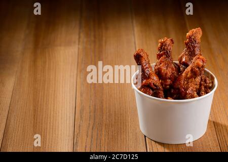 Portion de pilons de poulet frits sur une table en bois Banque D'Images