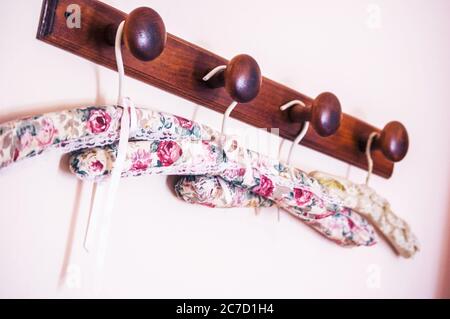Cintres de vêtements à motif fleur de gros plan sélective sur un brun tige en bois Banque D'Images