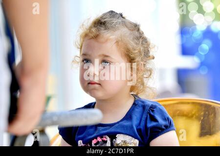 Une petite fille mignonne boit du jus d'orange en utilisant de la paille à boire .juillet 12, 2020 resen, macédoine Banque D'Images