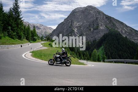 Conducteur de moto sur la route alpine, Autriche, Europe. Photographie en extérieur, paysage de montagne. Photographie de voyage et de sport. Vitesse et liberté Banque D'Images
