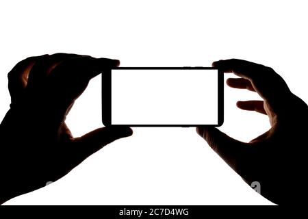 Silhouette de mains avec un smartphone qui prend des photos isolées sur fond blanc. Écran avec espace de copie. Modèle ou cache pour le design. Banque D'Images