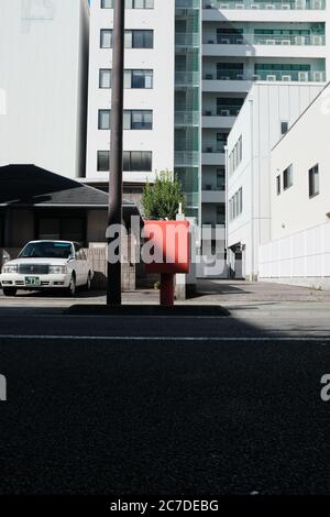 MATSUYAMA, JAPON - 23 septembre 2019 : une photo verticale d'une voiture blanche garée dans un garage près de bâtiments blancs Banque D'Images