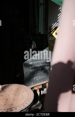 MATSUYAMA, JAPON - 23 septembre 2019 : un cliché vertical de mots écrits sur un tableau noir sur un stand devant un magasin Banque D'Images