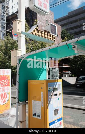 MATSUYAMA, JAPON - 23 septembre 2019 : une photo verticale d'une machine à stationner jaune par une route Banque D'Images