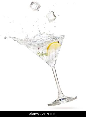 glaçons tombant dans un cocktail de martini de gin éclaboussant sur fond blanc Banque D'Images