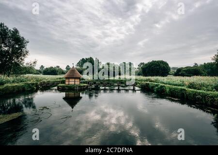 Pièges à anguilles et petite cabane de pêche au chaume sur la rivière Test, près du village de Longstock, Hampshire (Hants), Angleterre, Royaume-Uni Banque D'Images