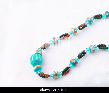Collier de perles turquoise multicolore isolé sur blanc Banque D'Images