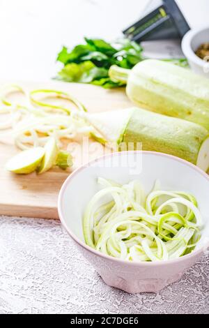 Pâtes végétaliennes de courgettes et courgettes sur planche à découper en bois. Des aliments sains végétariens Banque D'Images