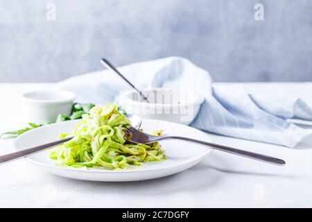 Des nuddles de Zucchini sains avec du pesto sur fond blanc Banque D'Images