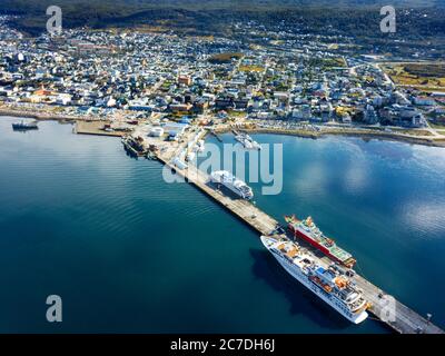 Vue aérienne par drone sur le port d'Ushuaia, le front de mer et les montagnes et la ville à l'arrière d'Ushuaia, Tierra del Fuego, Argentine. Banque D'Images