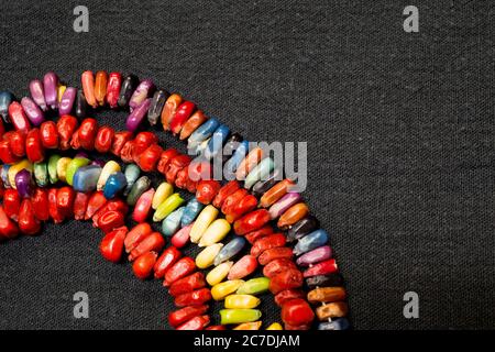 Des bonbons colorés en forme d'arc-en-ciel sur fond noir. Banque D'Images