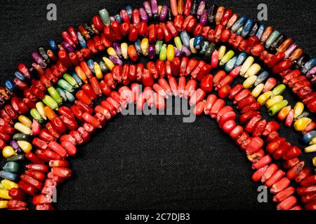 Des bonbons colorés en forme d'arc-en-ciel sur fond noir. Banque D'Images