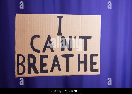 Je ne peux pas respirer. Message texte pour une action de protestation. Arrêter la violence. Inscription « Je ne peux pas respirer » sur le carton. Concept de la matière noire sur un flou bleu Banque D'Images