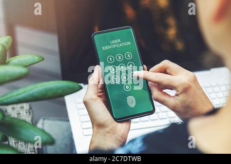 cyber-sécurité : femme utilisant une application mobile dans un smartphone pour l'authentification des utilisateurs de services bancaires sur internet Banque D'Images