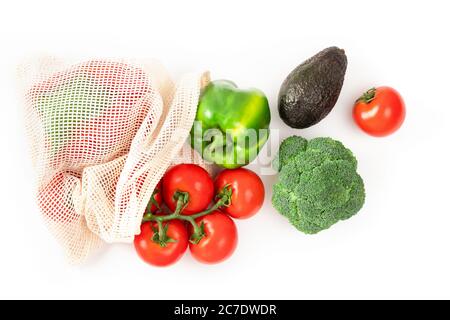 Tomate, poivre, avocat, brocoli dans un sac écologique réutilisable sur blanc. Un style de vie durable. Achat de nourriture sans plastique. Concept zéro déchet. Banque D'Images