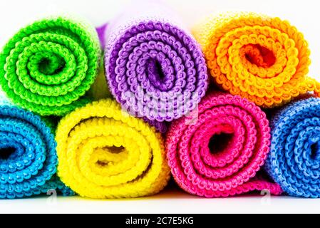 Arrière-plan composé de différentes couleurs de matériau en microfibre, enroulé et empilé l'un sur l'autre, vue avant, prise de vue macro. Banque D'Images