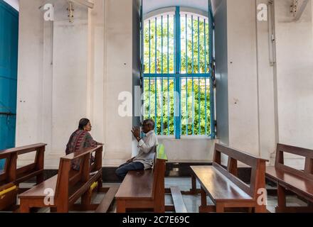 Pondichéry, Inde - février 2020 : un homme et une femme indiens âgés ayant une conversation sur les bancs à l'intérieur de la cathédrale Immaculée conception. Banque D'Images