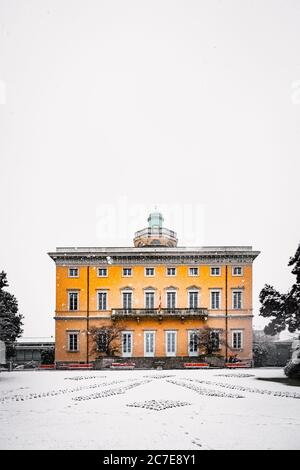 Plan vertical d'un bâtiment en béton jaune recouvert de neige sous le beau ciel clair Banque D'Images