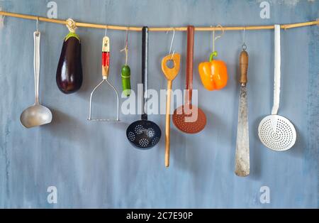 Divers ustensiles de cuisine et légumes vintage sur un mur rustique, bon espace de copie Banque D'Images