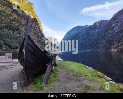 Bateau viking ancien bois drakkar avec tête de dragon gros plan sur la côte de Naeroyfjord entouré de montagnes, Gudvangen, Norvège Banque D'Images